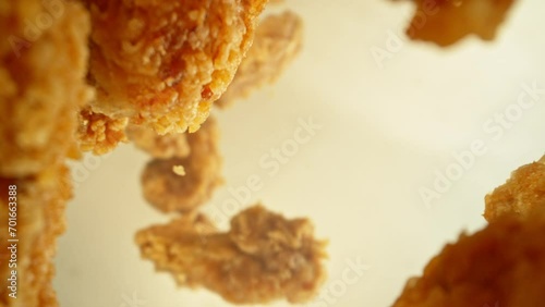 Super Slow Motion of Flying Fried Chicken Piecers on Golden Background. Camera Makes Rotation Move. Filmed on High Speed Cinema Camera, 1000fps. photo