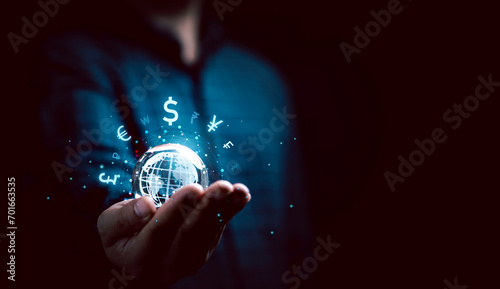 Businessman holding virtual glowing world with currency symbol include dollar yuan yen euro pound sterling won and ruble for global forex exchange and money trade transfers concept. photo