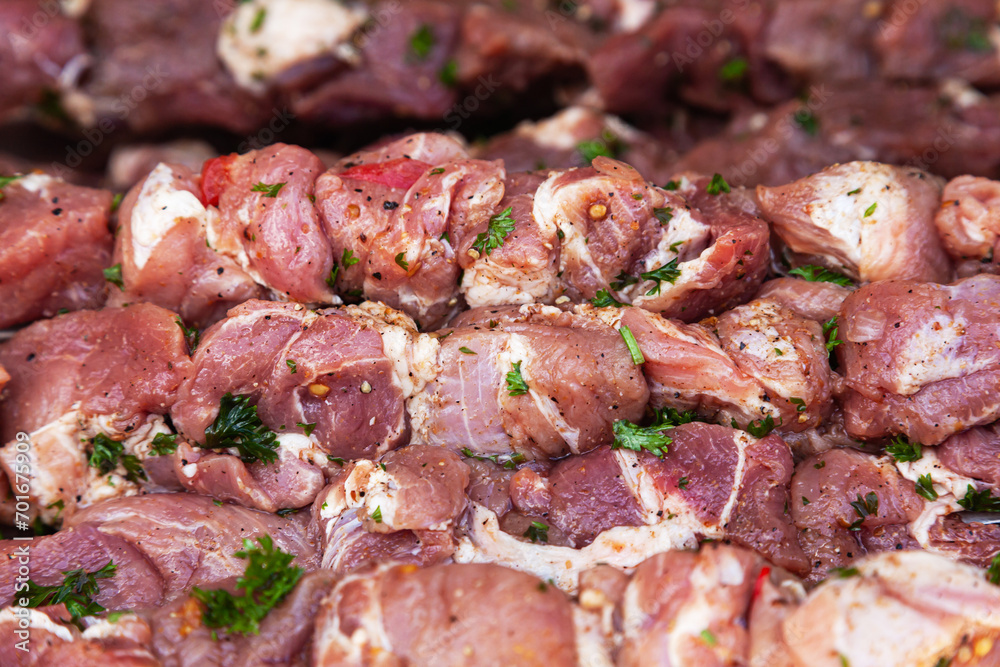 Prepared raw pork fillet pieces on skewers, ready for frying.