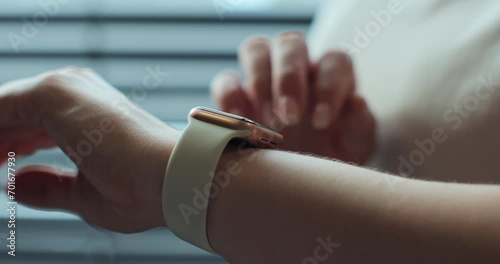Woman browsing modern smart watches in closeup. Smart watch on female wrist. Girl making gestures on a smartwatch. photo