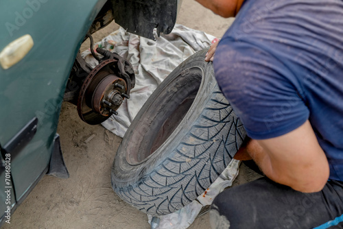 Man changing a tyre after a breakdown in a village near Soroca, Moldova