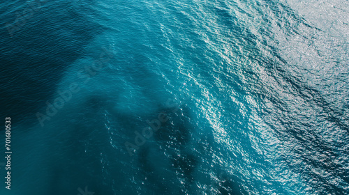 A calm, crystal clear ocean surface with subtle shades of blue creating a serene and minimalist background. Aerial view, Landscapes illustration, Generative AI  © Furkan