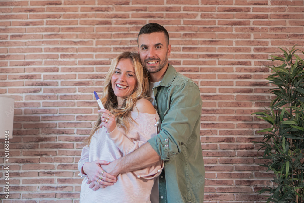 joyful-young-wife-showing-positive-pregnancy-test-result-to-her-husband