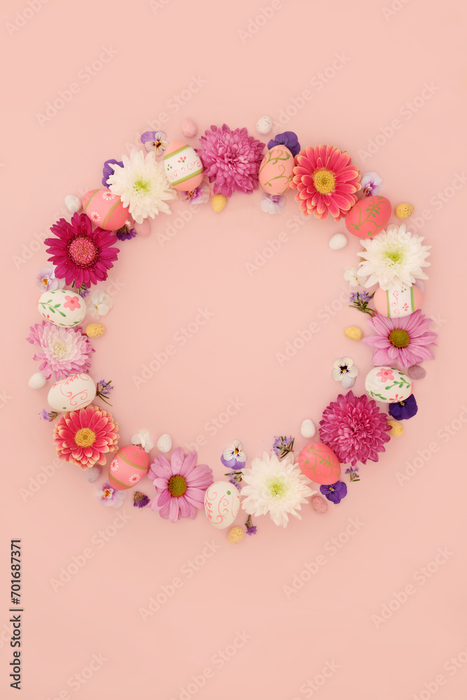 Easter wreath with decorated eggs and mini eggs  on pink background. Decorative flower garland for traditional seasonal nature floral edible food design.