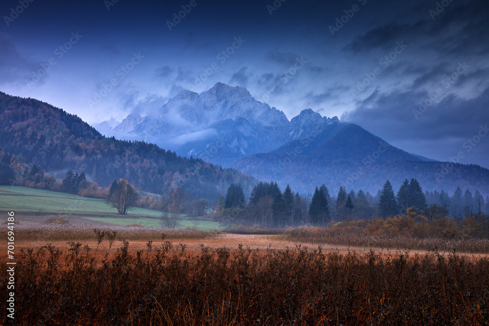 Slovenia landscape. Zelenci lake natural reserve, Kranjska Gora, Slovenia. Foggy Triglav Alps with forest, travel in nature. Beautiful sunrise with blue sky, green nature. - obrazy, fototapety, plakaty 