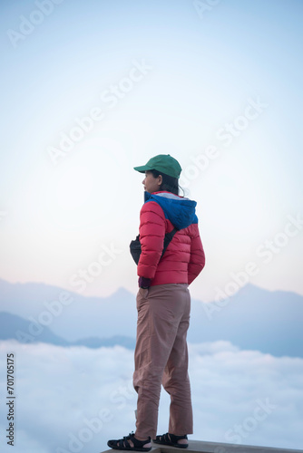 young woman travelers looking at the sunrise and the sea of mist on the mountain in the morning, travel lifestyle concept