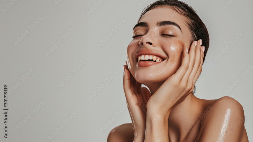 Skincare. Woman with beautiful face touching healthy facial skin. Woman smiling while touching her flawless glowy skin with copy space for your advertisement, skincare