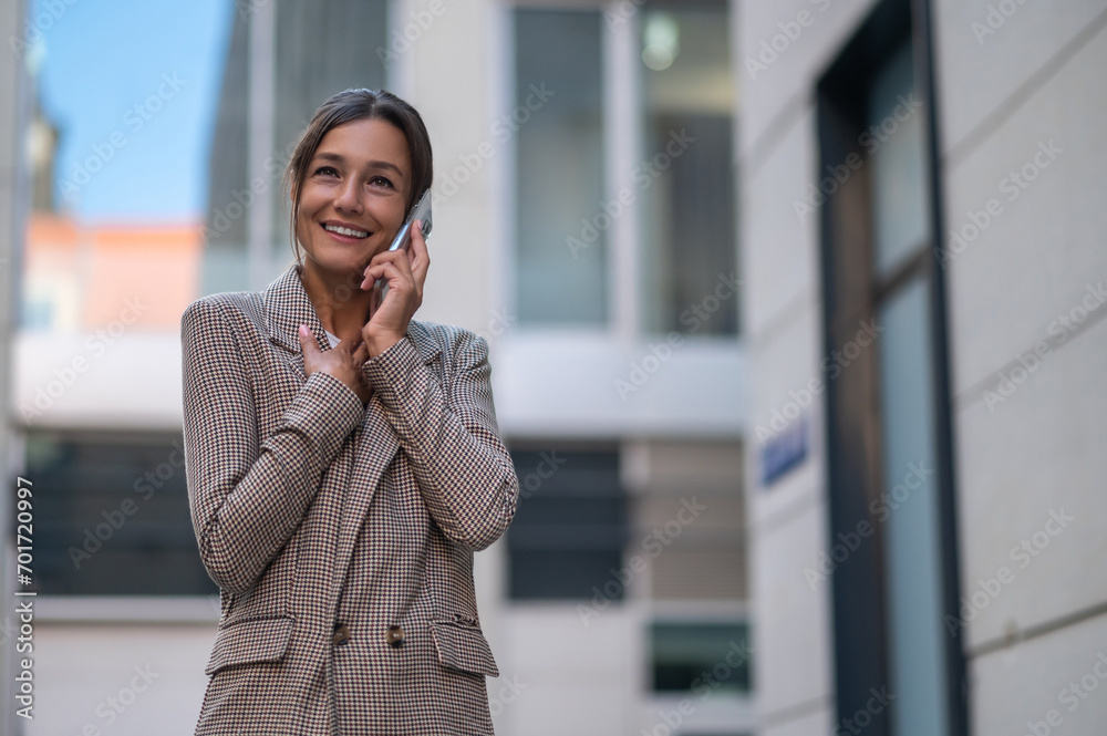 Woman making business call on cell on town street outdoors. Woman making business call on cell on town street outdoors.