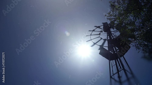 American farm windmill.
A farm windmill in California, sun in the frame and seeds floating in the air. photo