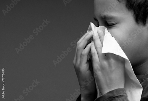 asthmatic breathing problems catching the flu child blowing nose after having a cold with grey background with people stock photo photo