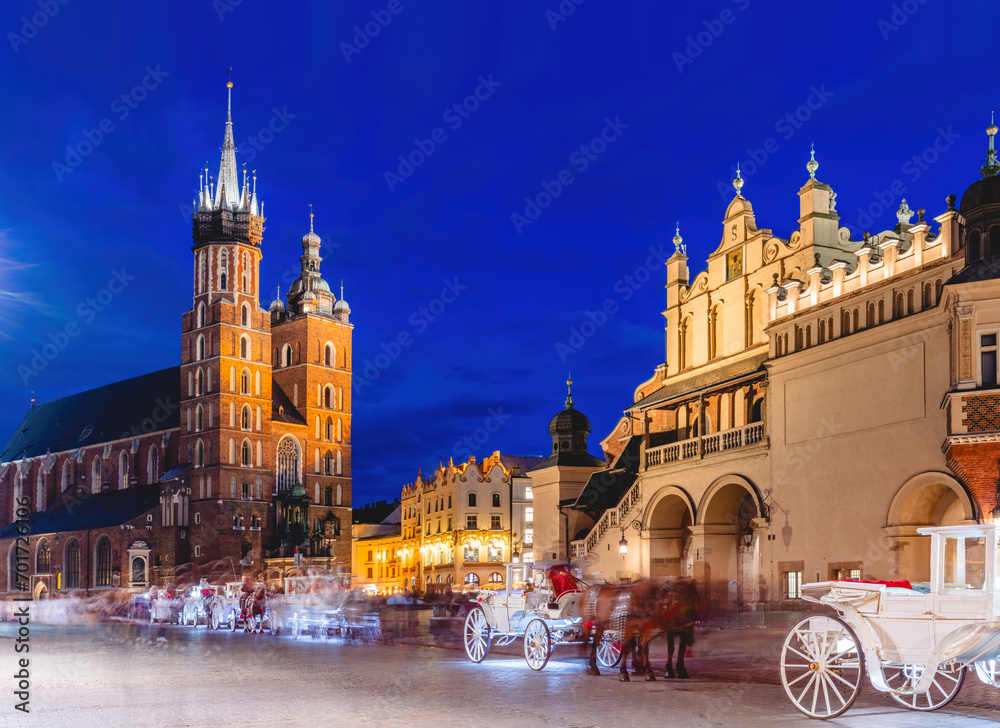 Horse carriages in the market square at the evening old town in Cracow, Poland