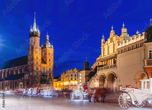 Horse carriages in the market square at the evening old town in Cracow, Poland