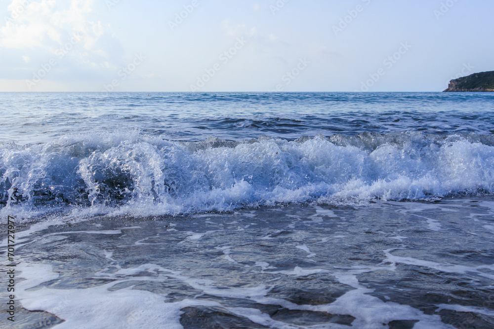The sea in blue and green colors with crashing waves on a stormy day in Agios Georgios on the island of Corfu The sea in blue and green colors with crashing waves on a stormy day in Agios Georgios on the island of Corfu