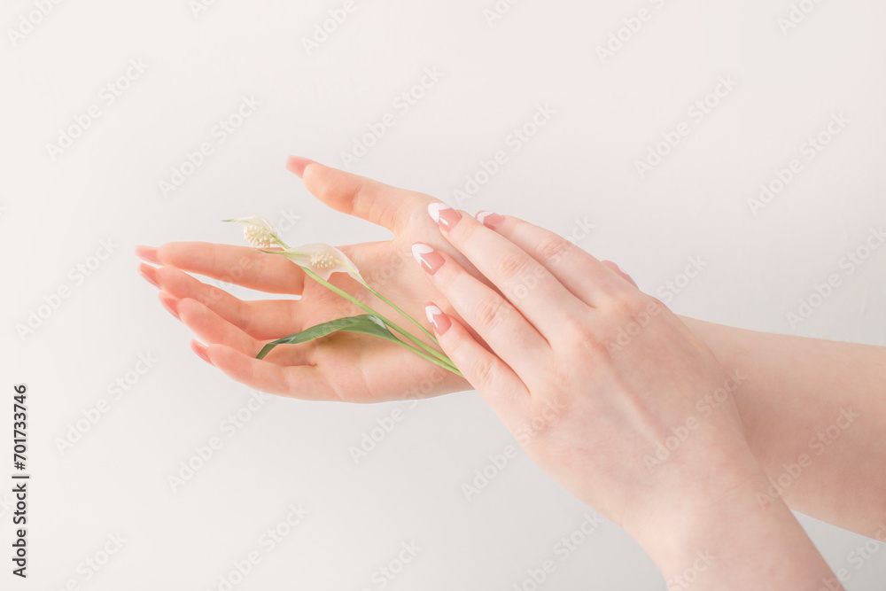 Naklejka premium female hands with beautiful long nails with flowers on white background