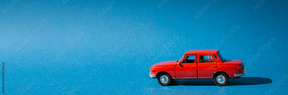 Red toy car isolated on blue background