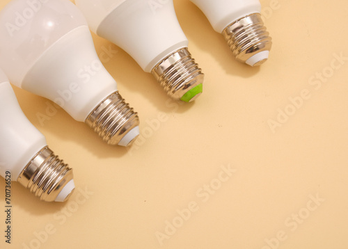 Several energy saving light bulbs lie in a row. Copy space for text.