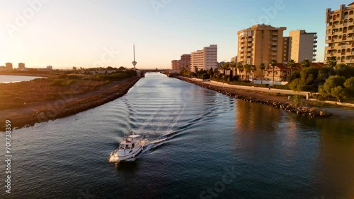 Boat passing through the Estacio Canal that connects the Mar Menor to the Mediterranean Sea in La Manga, Cartagena. The mobile bridge of the gola can be seen. photo