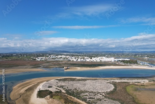 aerial drone view of climate in praia da fuseta in algarve portugal with fields, lakes and beach next to the atlantic ocean and nature