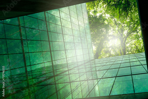 Eco-friendly building in modern city. Sustainable glass office building with trees for reducing CO2. Green architecture. Building with green environment. Sustainability corporate. Net zero emissions. photo