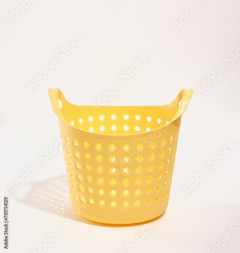 Yellow laundry basket empty stands on the table. Laundry room.
