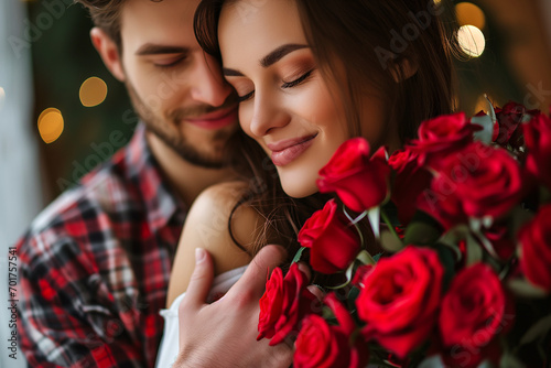 beautiful and happy couple with bouquet of red roses