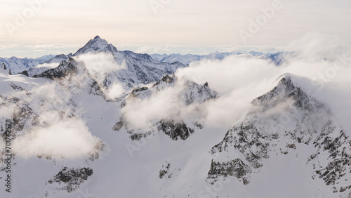 mystic snow covered mountains with clouds in Swiss Alps photo