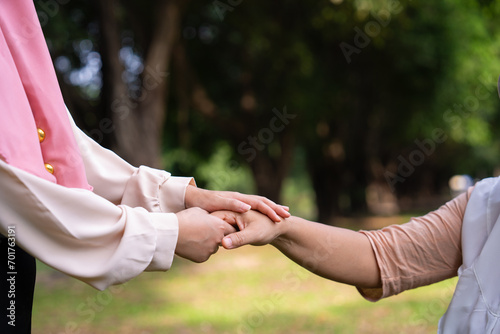 Muslim careful caregiver or nurse taking care of the patient in the hospital park. Happy Muslim mother in hijab hugging daughter. Concept of Savings and Senior Health Insurance, a Happy Family