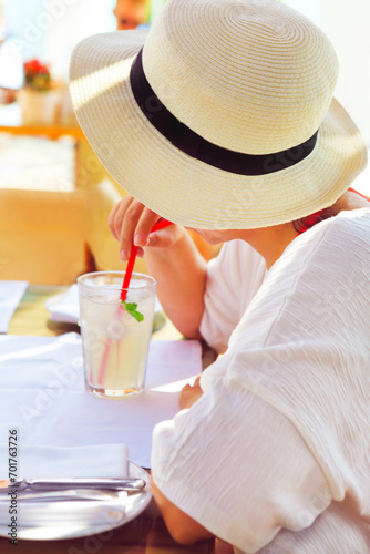 Woman in straw hat drinking lemonade juice photo
