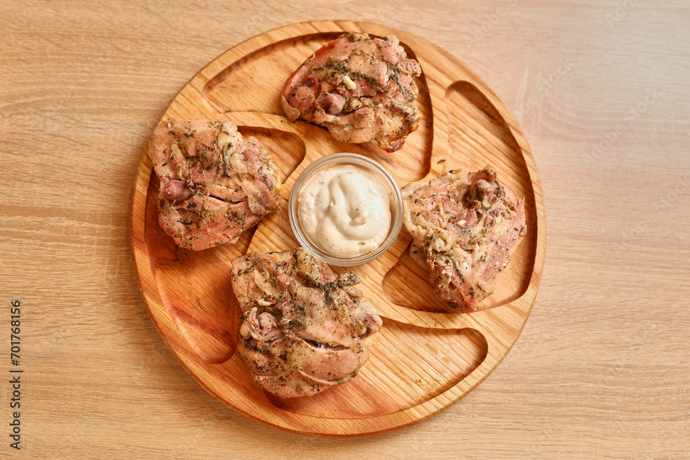 Put the cooked chicken on a wooden plate Put the cooked chicken on a wooden plate