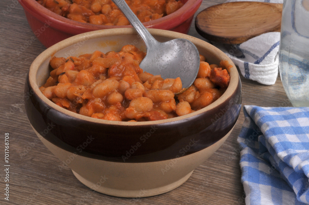 Fototapeta premium Bol de haricots blancs sauce tomate avec une cuillère en gros plan