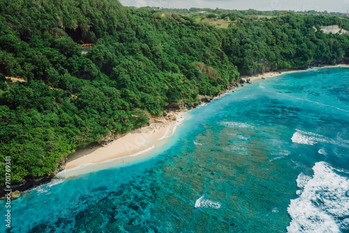 Paradise beach with blue tropical ocean and waves in Bali. Aerial view
