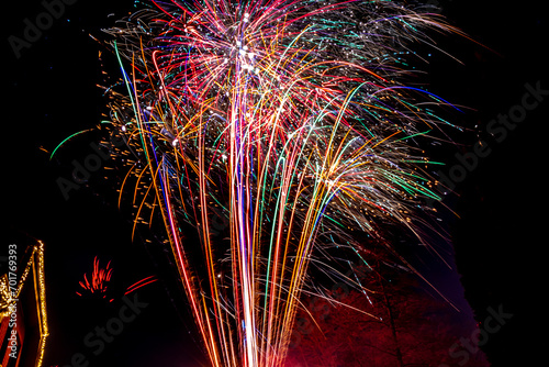 Farbenprächtiges Silvester-Feuerwerk in originaler Umgebung mit Haus und Baum im Hintergrund