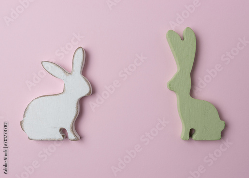 Two Easter bunnies decoration on pink background. Minimal Easter concept.