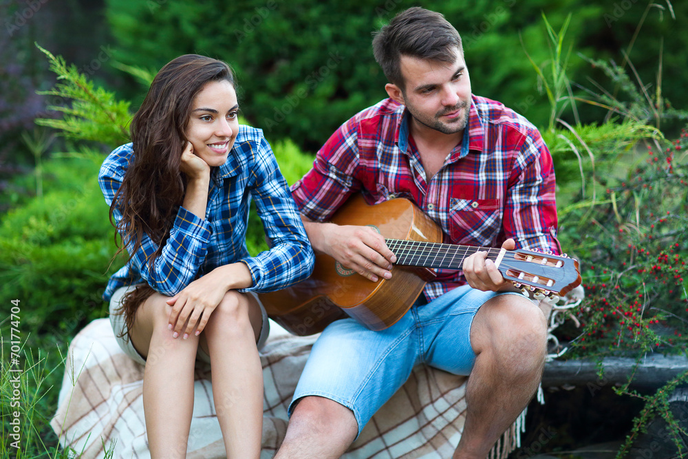 Young couple with guitar outdoors