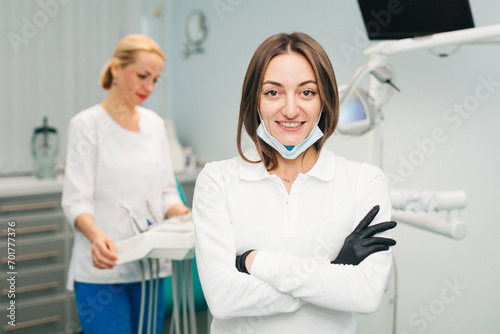 Woman doctor dentist on the background of a modern dental clinic. Work of a doctor and nurse in dentistry. The concept of advertising dental services and healthy teeth.