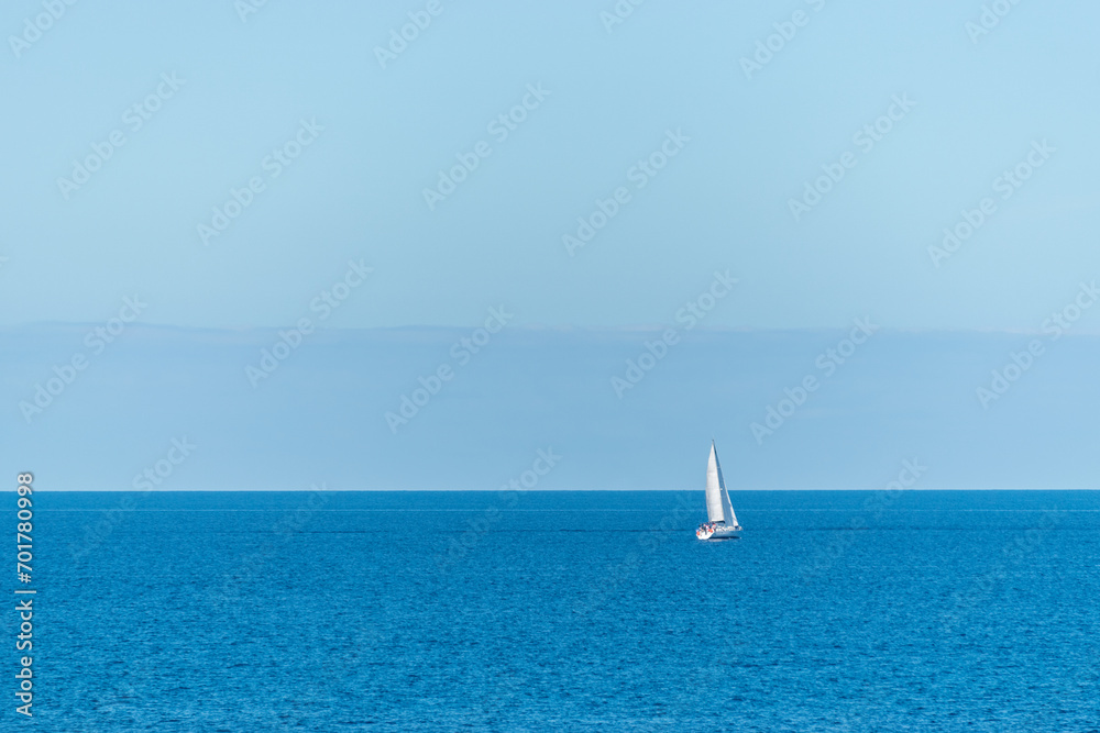 Fototapeta premium White sailboat at the beautiful blue sea.