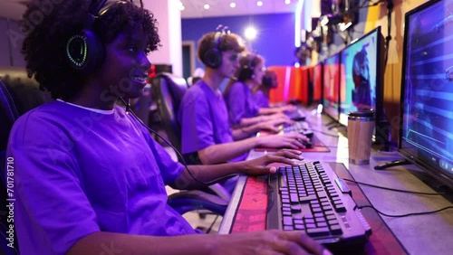 close-up on woman playing online video games with her group of gamer friends in uniform in the background