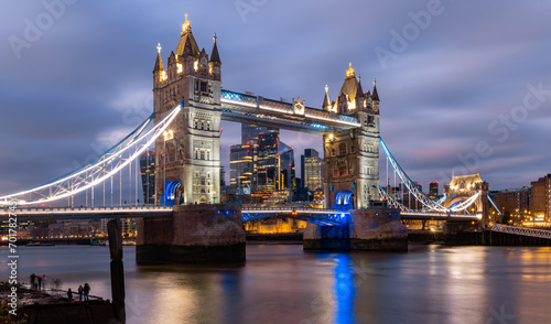 Iconic Tower Bridge in London spanning over river Thames at evening twilight with colorful illumination at christmas time. Landmark, sight and tourist attraction in english metropole from river bank.