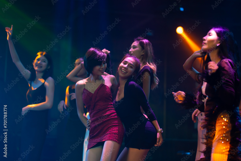 Fototapeta premium Nightlife and disco dance party concept. Sexy young woman people and friends dancing in night club. music festival. Cheerful Happy fun Asian people dance in night club