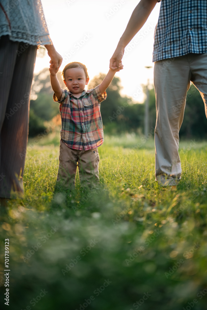 Fototapeta premium happy harmonious Asian family outdoors concept, Asian mother and son have activities happy fun together on holidays, grass land with sunlight