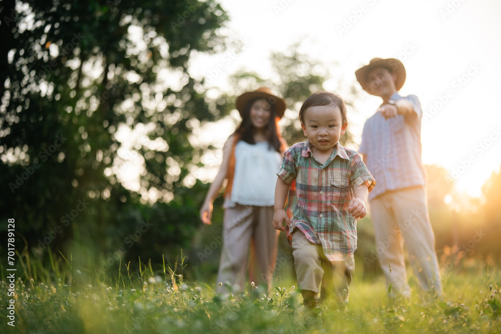 Fototapeta premium happy harmonious family outdoors concept father and mother and son have activities together on holidays, nature grassland field