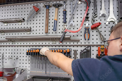 A worker selects a tool for work and repair in a locksmith workshop. photo