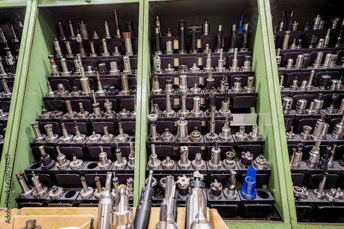 Mills and cutting tools for working on a CNC machine are arranged. in tool racks. photo