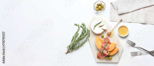 Tasty melon with prosciutto, cheese, olives and honey on white background with space for text