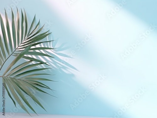 Blurred shadow from palm leaves on the light blue wall. Minimal abstract background for product presentation. Spring and summer. 