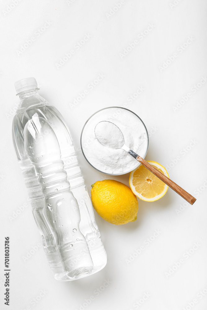 Bottle of vinegar, baking soda and lemons for cleaning on white background Bottle of vinegar, baking soda and lemons for cleaning on white background