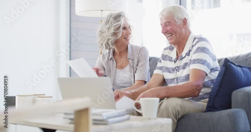 Senior couple, laptop and bills for budget, financial assets and planning pension investment at home. Happy man, woman and documents for online banking, tax savings or insurance policy for retirement photo