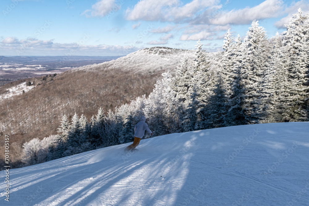 Downhill snowboarder on beautiful day