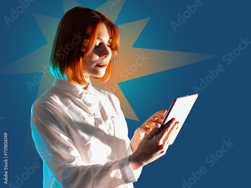 Woman with tablet computer. Electronic gadget in hands girl. Girl uses tablet to surf internet. Student reads e-book. Tablet computer in hands lady. Woman visits websites. Female with gadget on blue