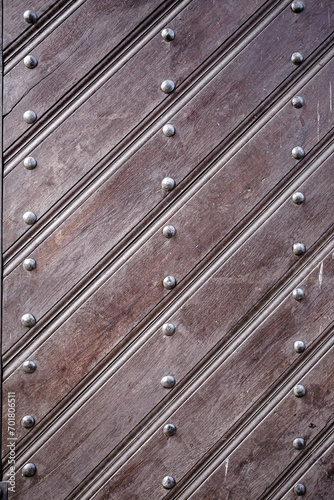 Old surface made of diagonal wooden slats with metal rivets